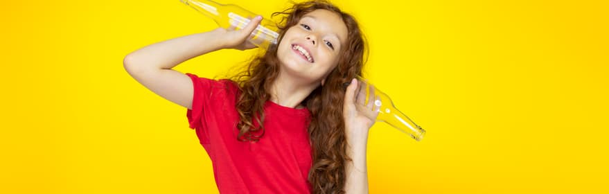 Fille sur fond jaune avec bouteilles en verre