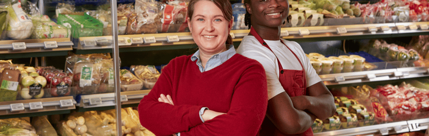 HAppy retailers in front of fruit section