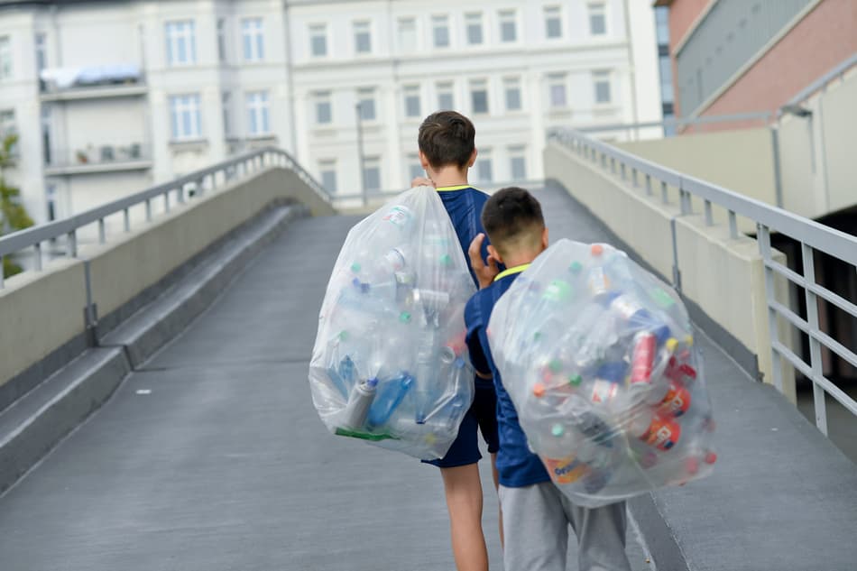 Boys carrying bags  with returnable bottles