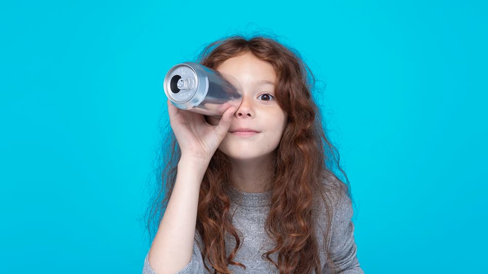 Girl holding beverage can up to eye like a periscope