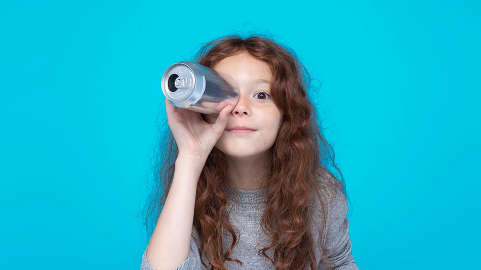 Fille tenant une canette au niveau de son œil, comme un périscope