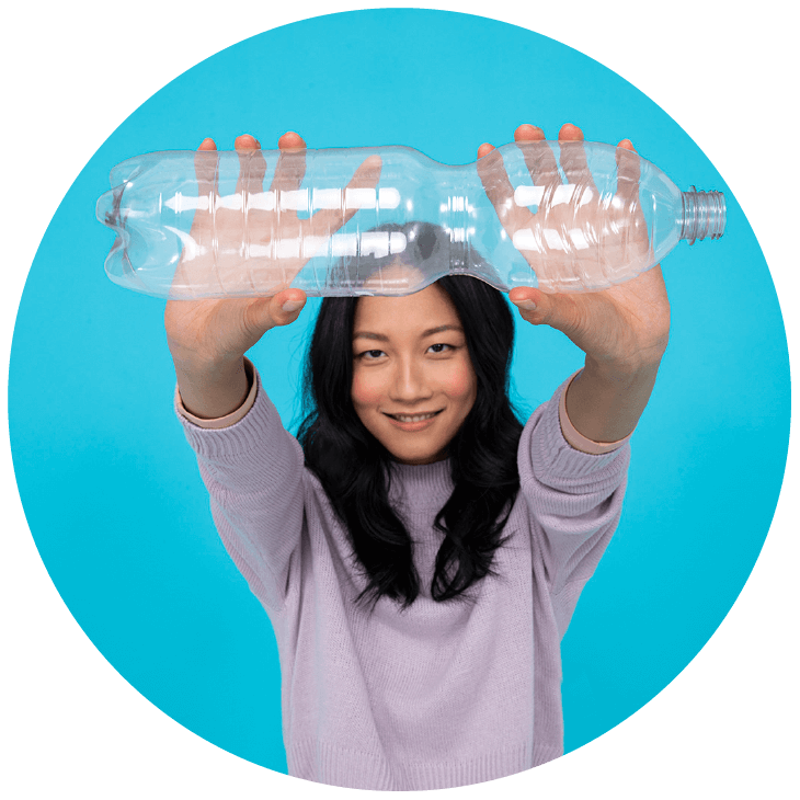 Femme tenant une bouteille en plastique à bout de bras