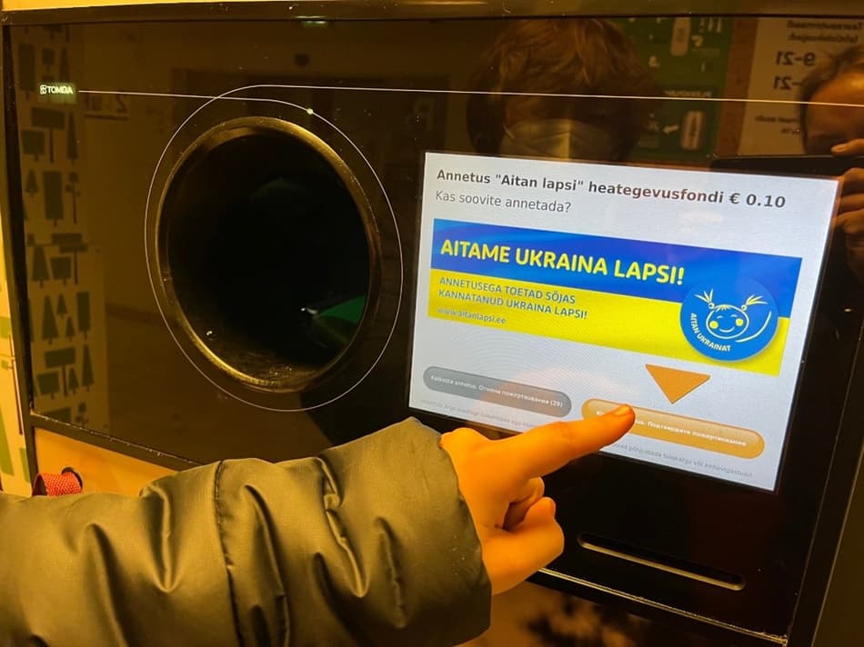 Recycler donating to Aitan Lapsi on TOMRA reverse vending machine