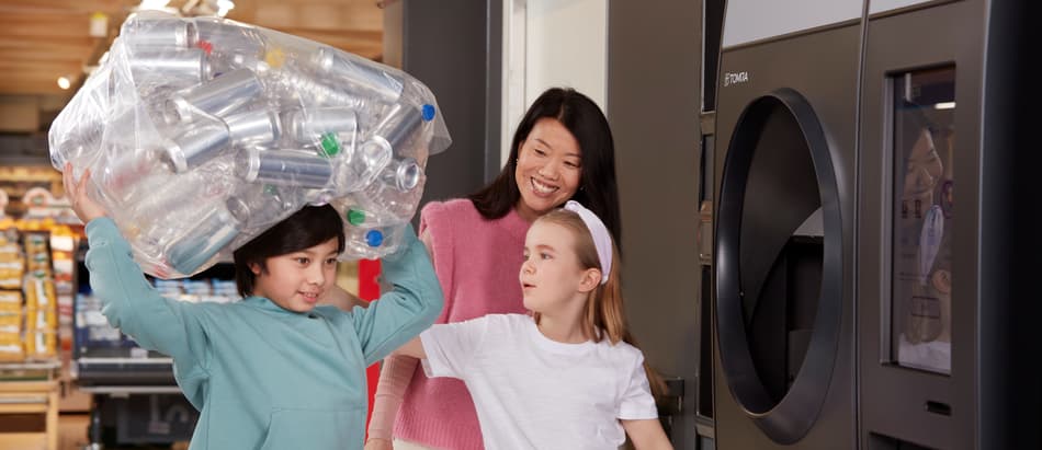 Imagen de una familia devolviendo envases a una máquina de vending inverso