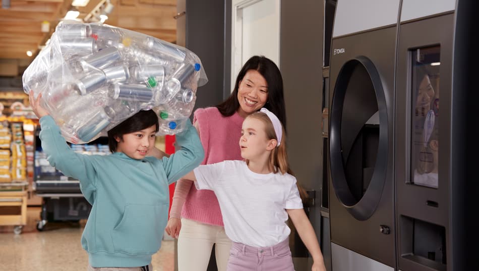 Imagen de una familia devolviendo envases a una máquina de vending inverso