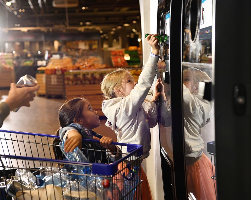 Family returning bottles at TOMRA reverse vending machine