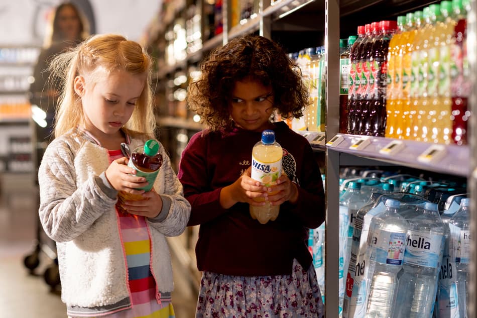 Girls looking at return label on plastic bottles