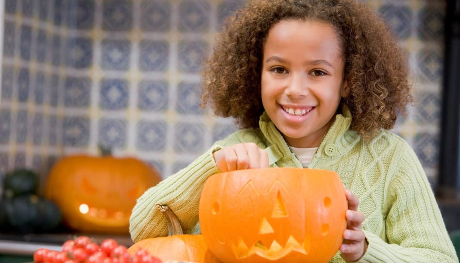 Imagen de una chica tallando calabazas