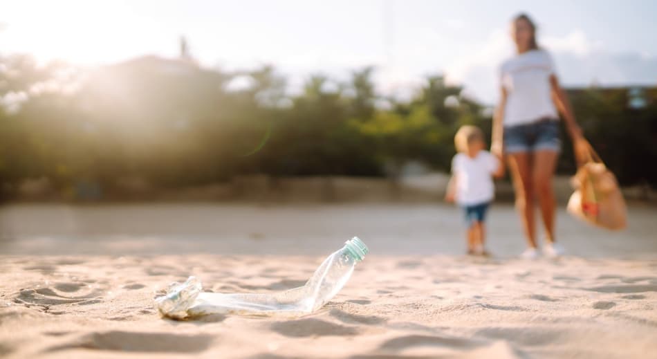 Family picking up bottle litter on beach