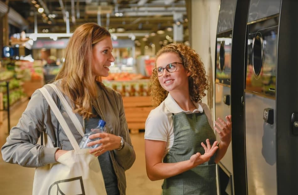 Imagen de un consumidor y un minorista en una máquina de vending inverso