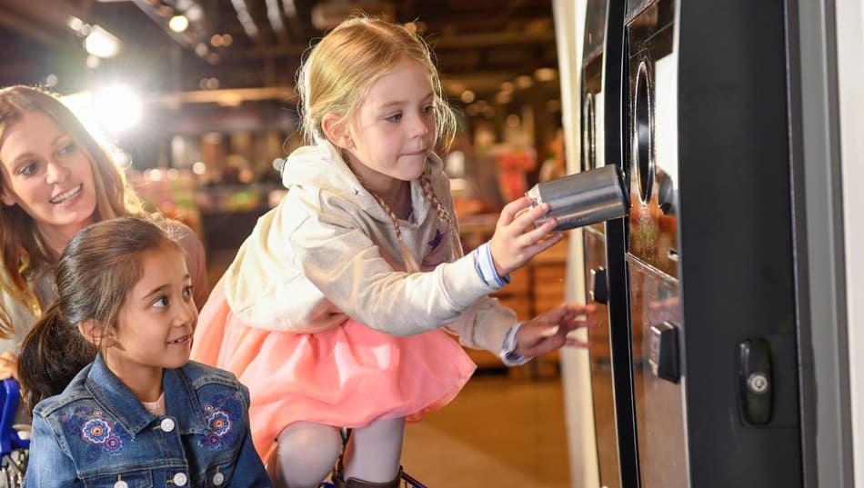 Image of family returning cans to reverse vending machine