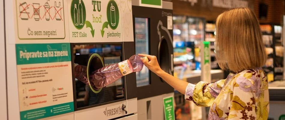 Woman feeding bottles in the reverse vending machine