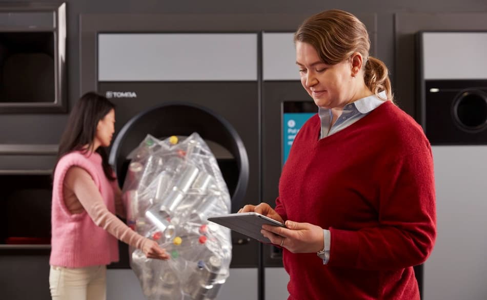 Image of retailer using tablet at reverse vending machine