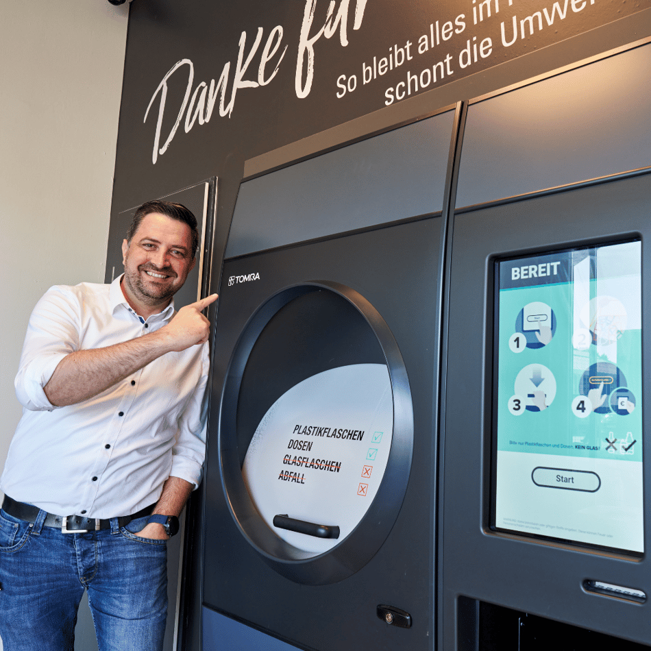 Robin Mohr, TOMRA Sales representative in front of TOMRA reverse vending machine